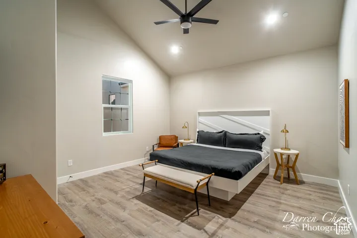 Vaulted ceiling featuring a matte black finish ceiling fan, wood-finish flooring, and recessed lighting