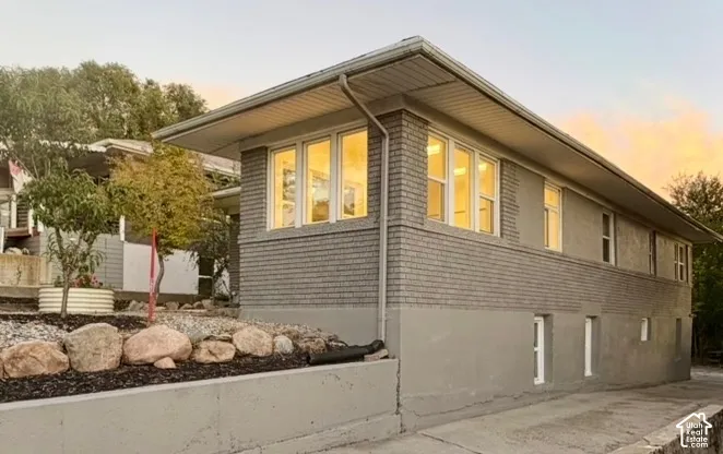 Modern residence showcasing a clean-lined architectural design with horizontal shingle siding and stacked stone accents