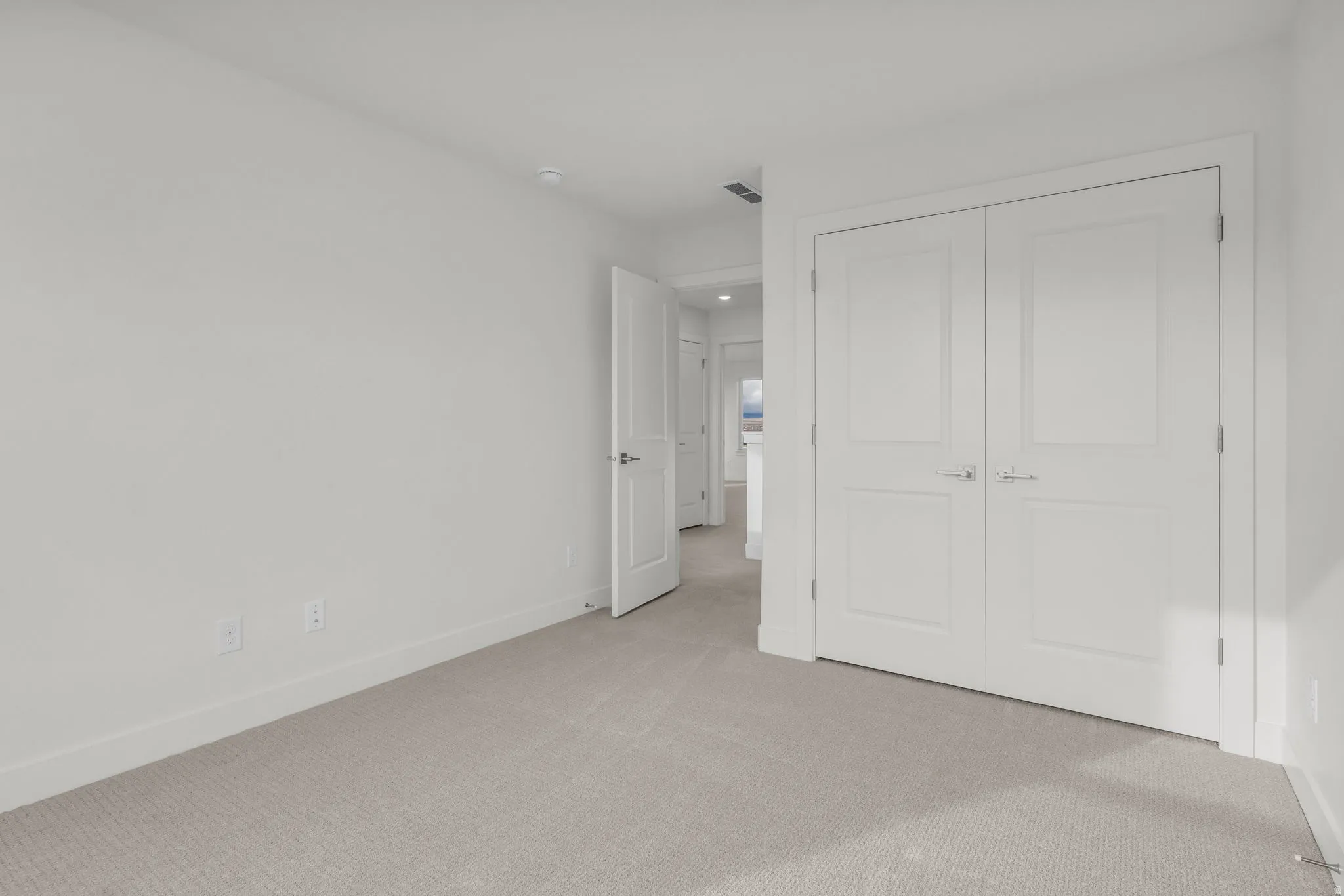 Neutral carpet flooring, white walls, recessed lighting, and white panel doors with brushed nickel hardware