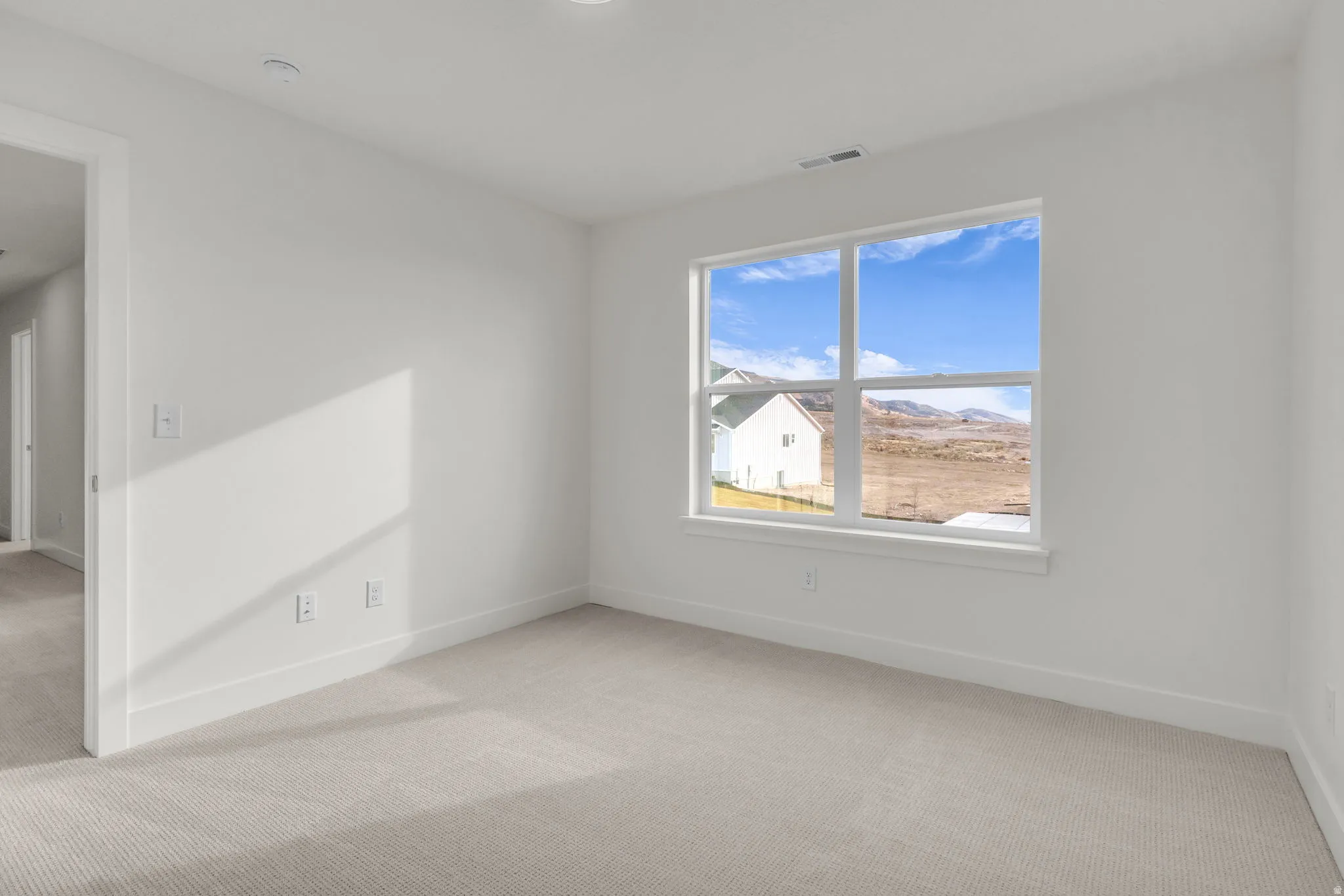 Carpeted flooring with white wall finishes, recessed lighting, and a large window