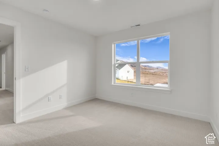 Carpeted flooring with white wall finishes, recessed lighting, and a large window