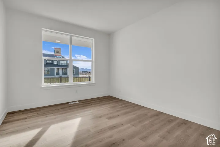 Wood-finish flooring, white painted walls, and a large window with white trim