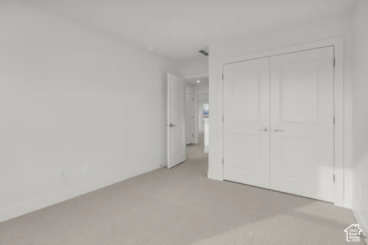 Neutral carpet flooring, white walls, recessed lighting, and white panel doors with brushed nickel hardware