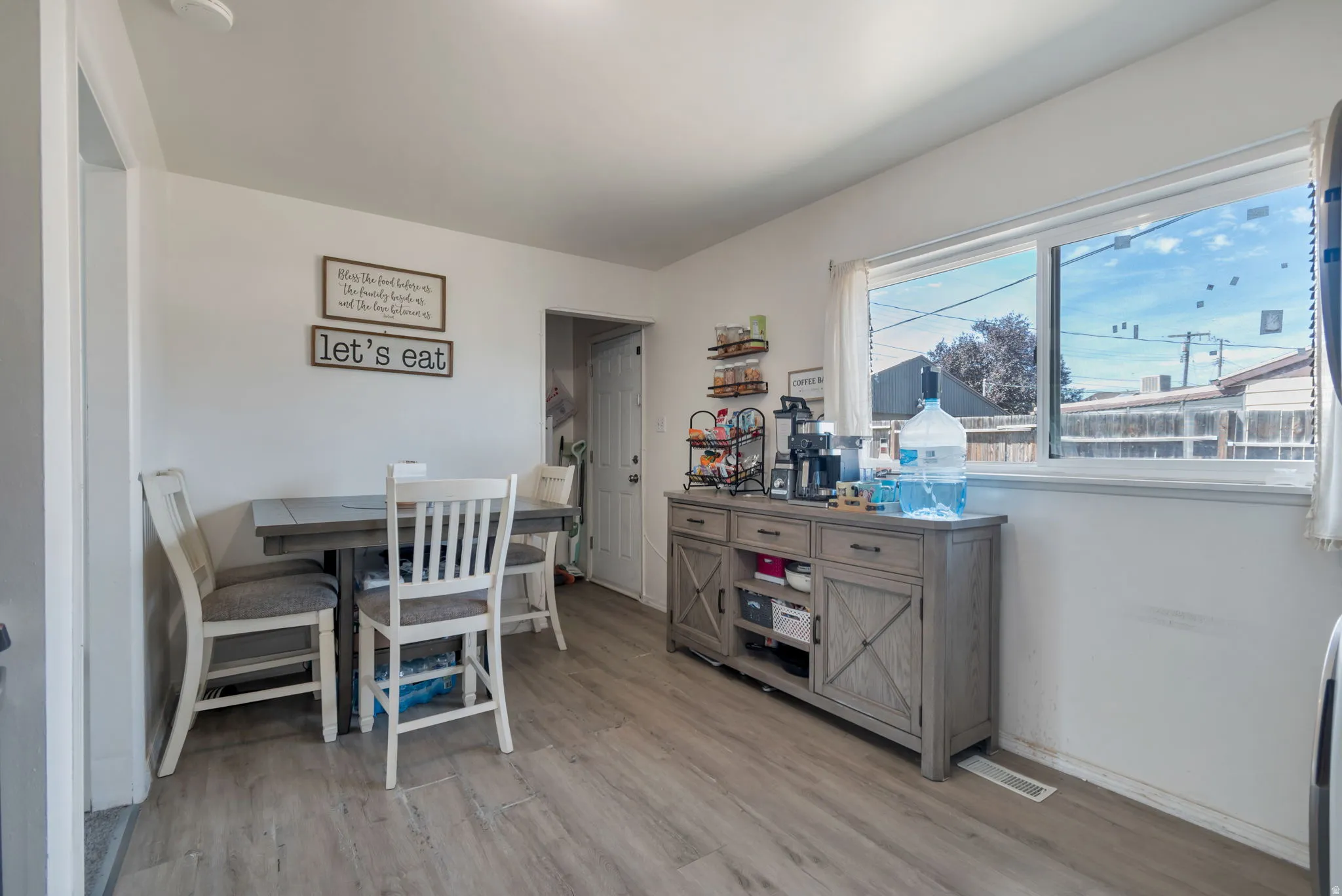 Wood-finish flooring throughout, white walls, and a large window providing natural light