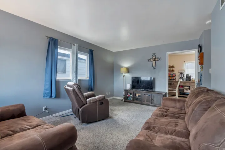 Carpeted flooring, light blue wall paint, and white trim