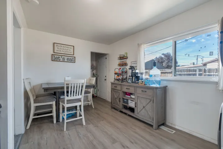 Wood-finish flooring throughout, white walls, and a large window providing natural light