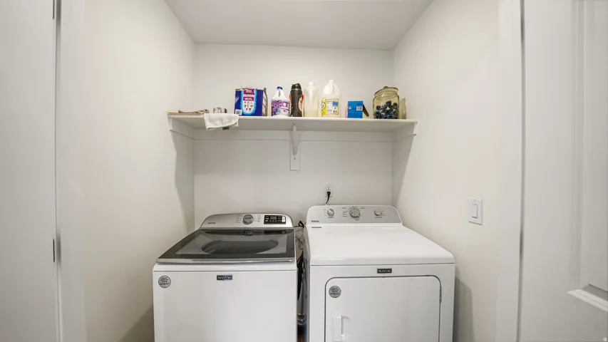 White laundry area featuring an upper shelf