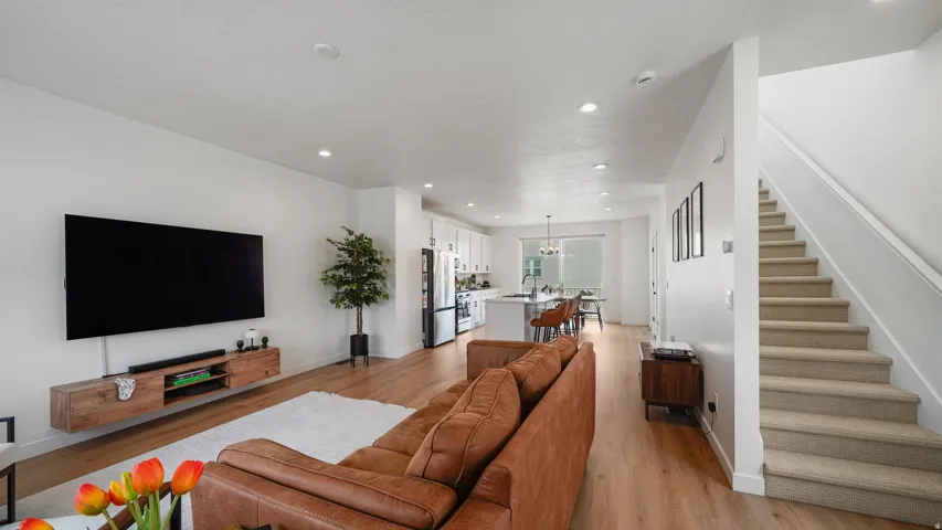 Open-concept living area with wood-finish flooring, recessed lighting, and a neutral color palette