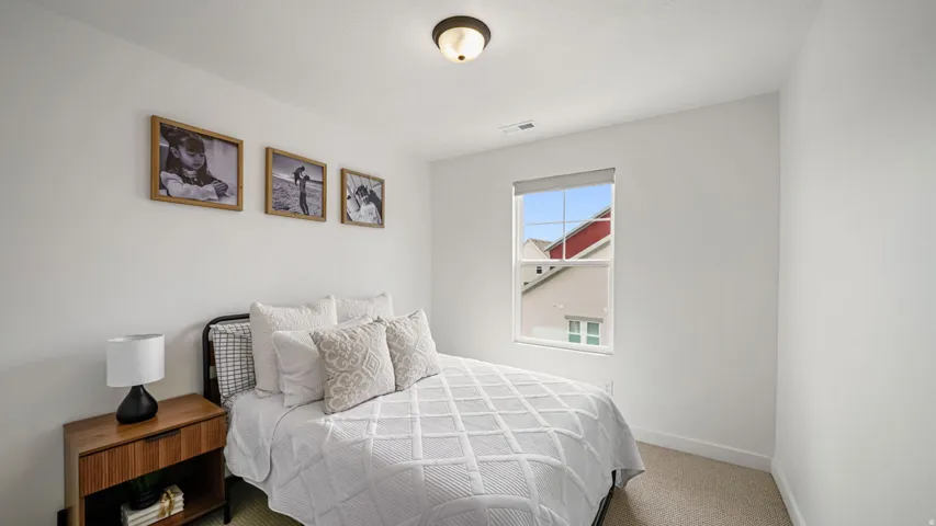 Recessed window with roller shade, neutral wall paint, ceiling-mounted light fixture, and carpeting
