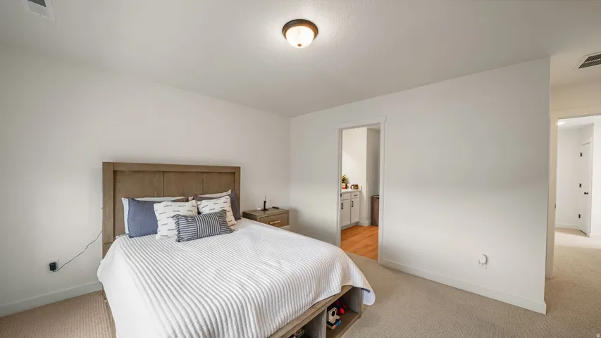 Carpeted flooring, recessed lighting, and a neutral color palette