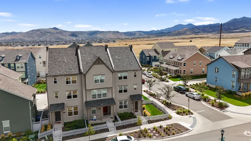 Modern townhome architecture featuring a neutral-toned exterior, gabled rooflines, and multiple windows
