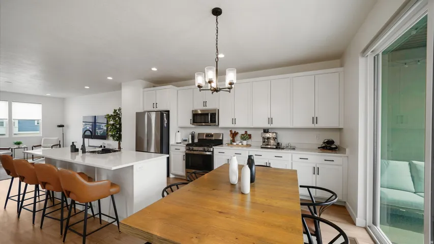Open-concept kitchen with white cabinetry and stainless steel appliances