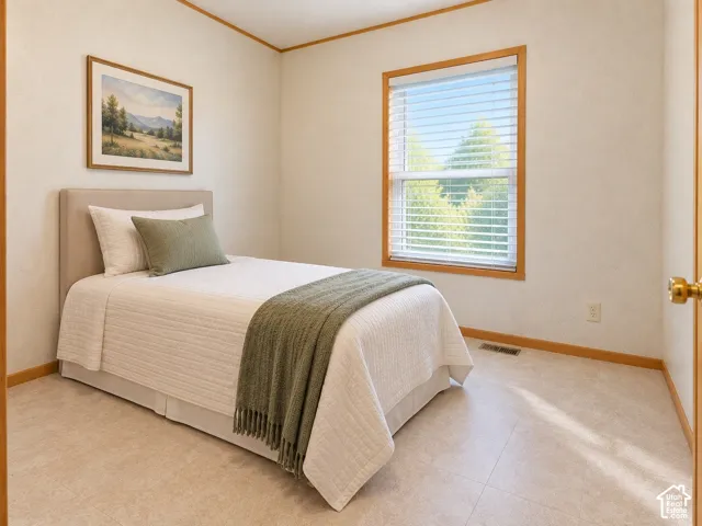 3rd Bedroom. Neutral wall finish, wood trim details, window with horizontal blinds, and light-toned flooring
