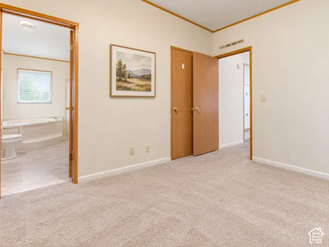 Primary Suite New  carpeted flooring, light wood-toned trim, and a built-in jetted tub