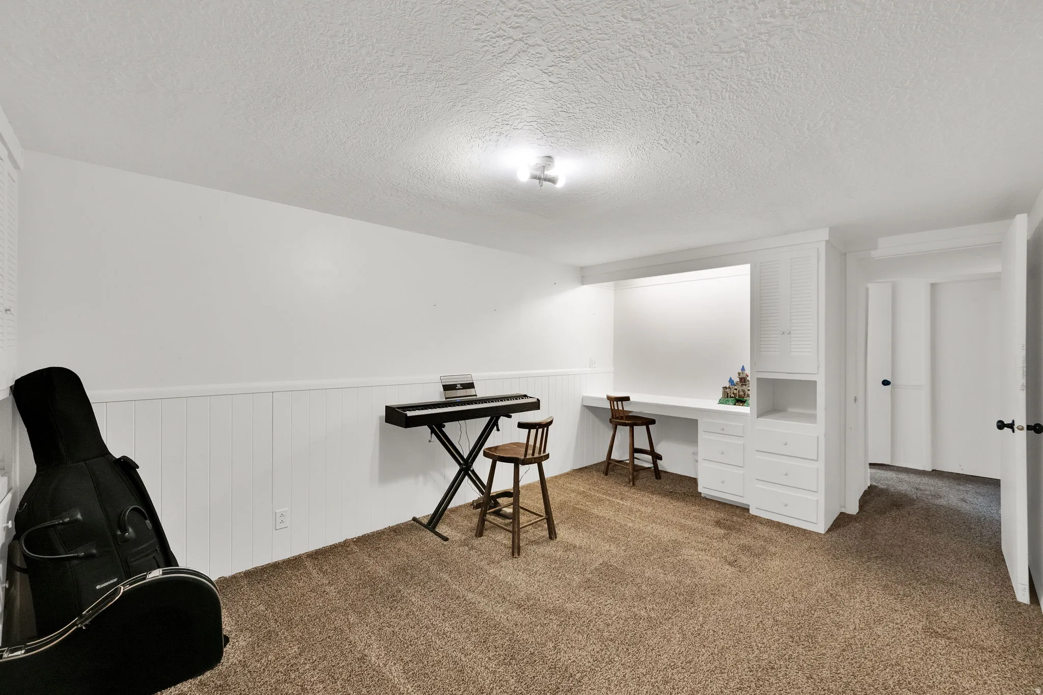 Built-in desk with integrated shelving and storage drawers, complemented by white wainscoting