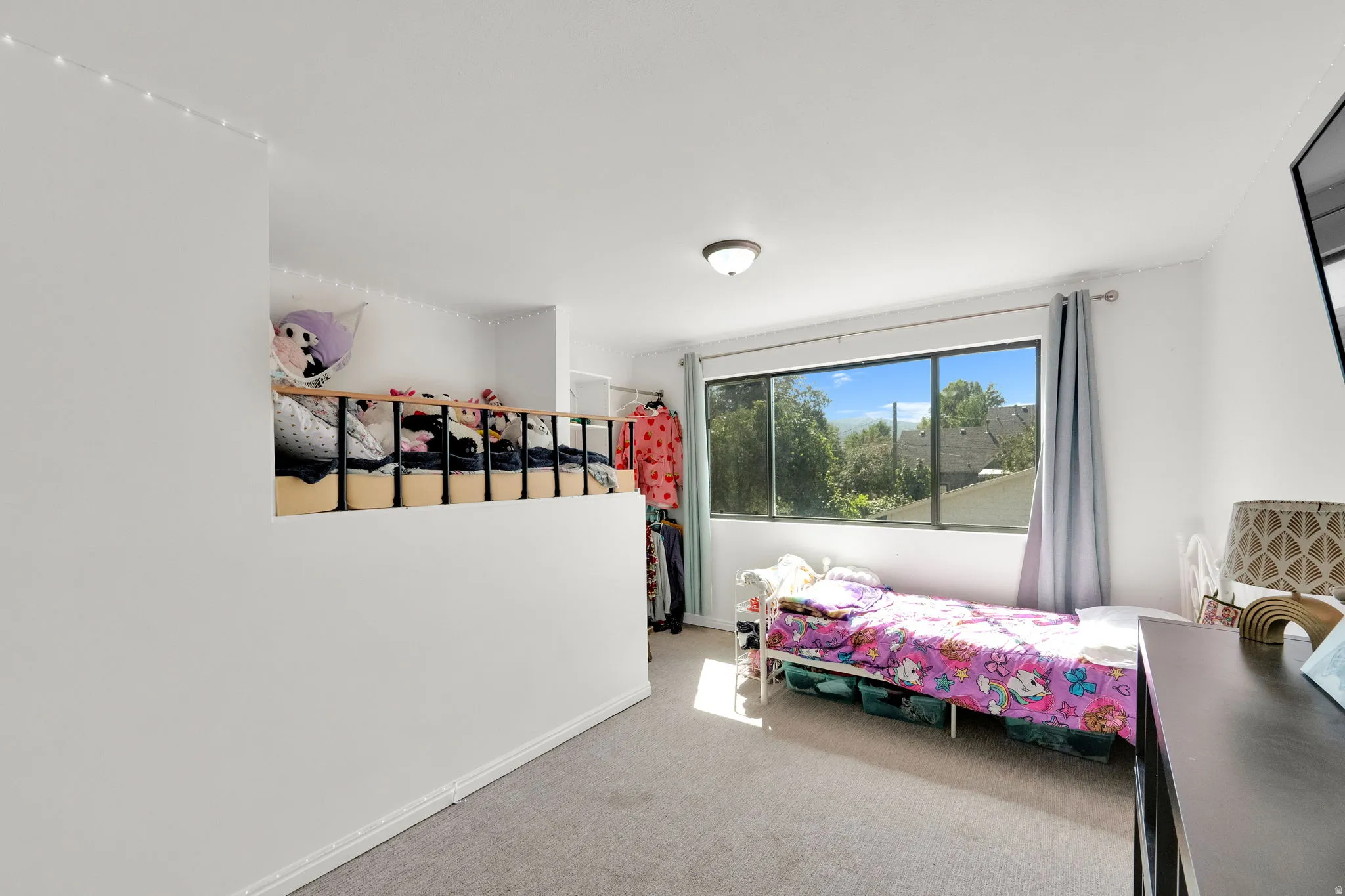 Loft space with a partial wall and a black metal railing