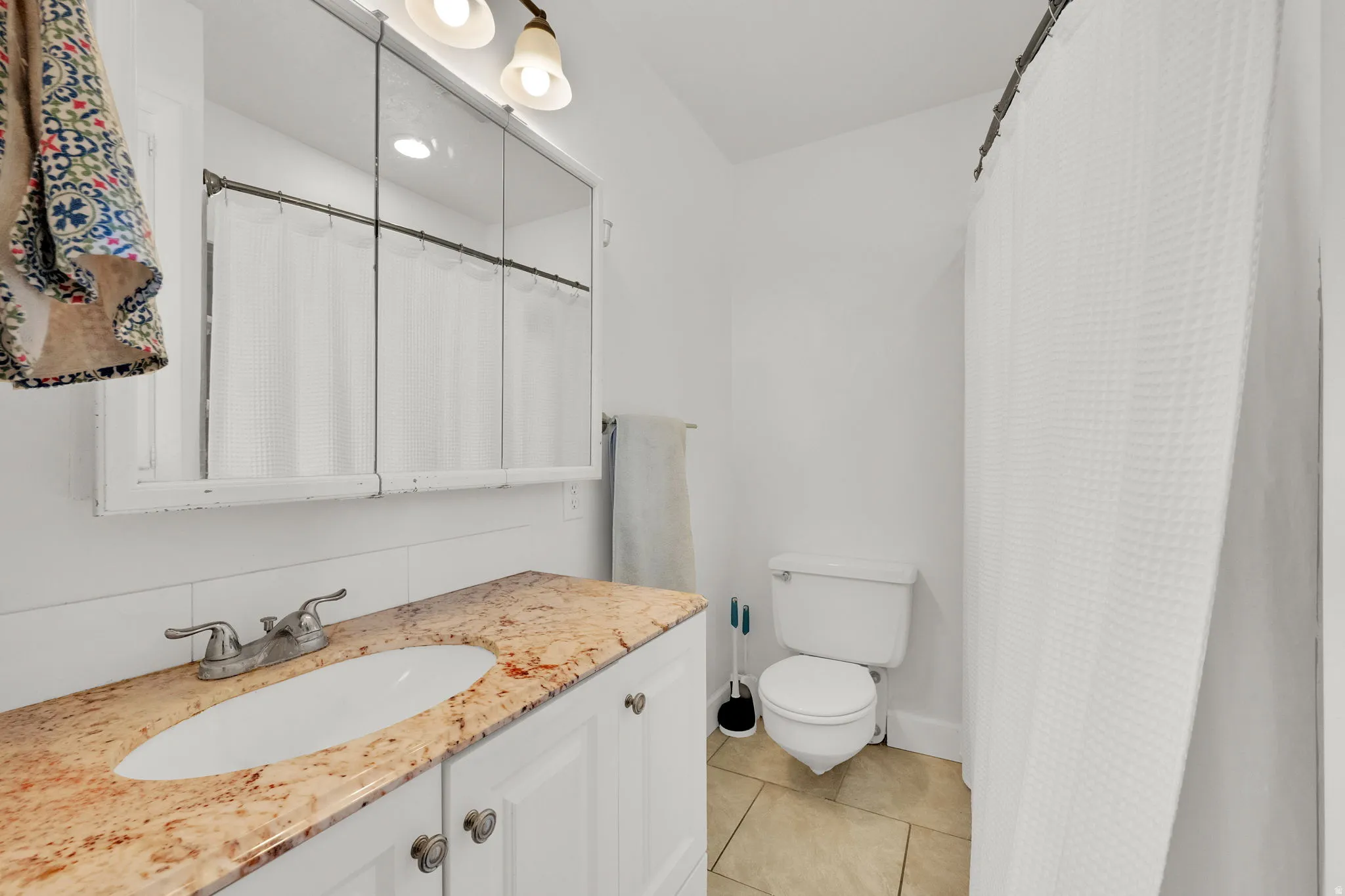 Vanity with a stone countertop, an integrated sink, and an undermount cabinet