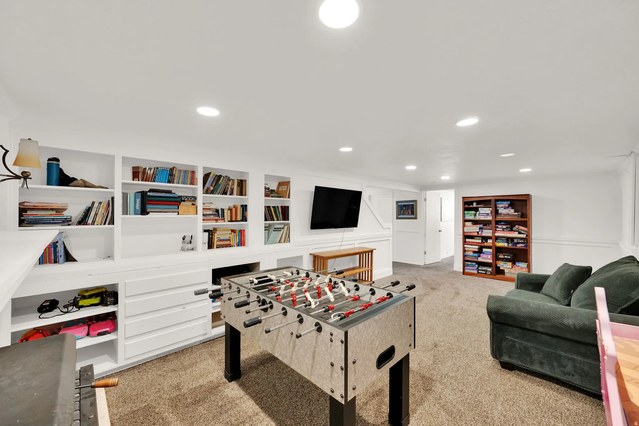 Recessed lighting, built-in shelving, wainscoting, and carpet flooring