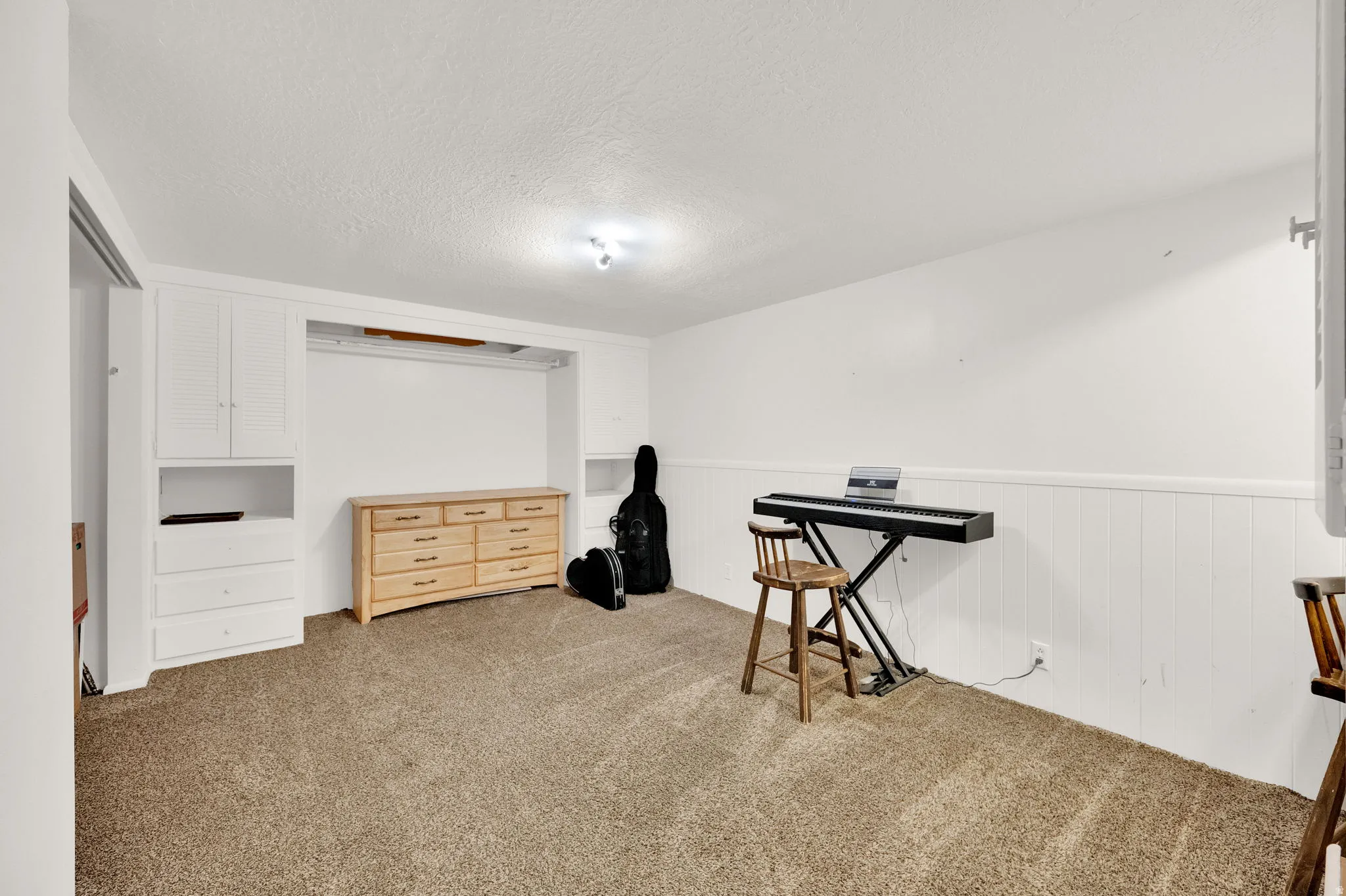 Built-in cabinetry, recessed wall niche, and track lighting