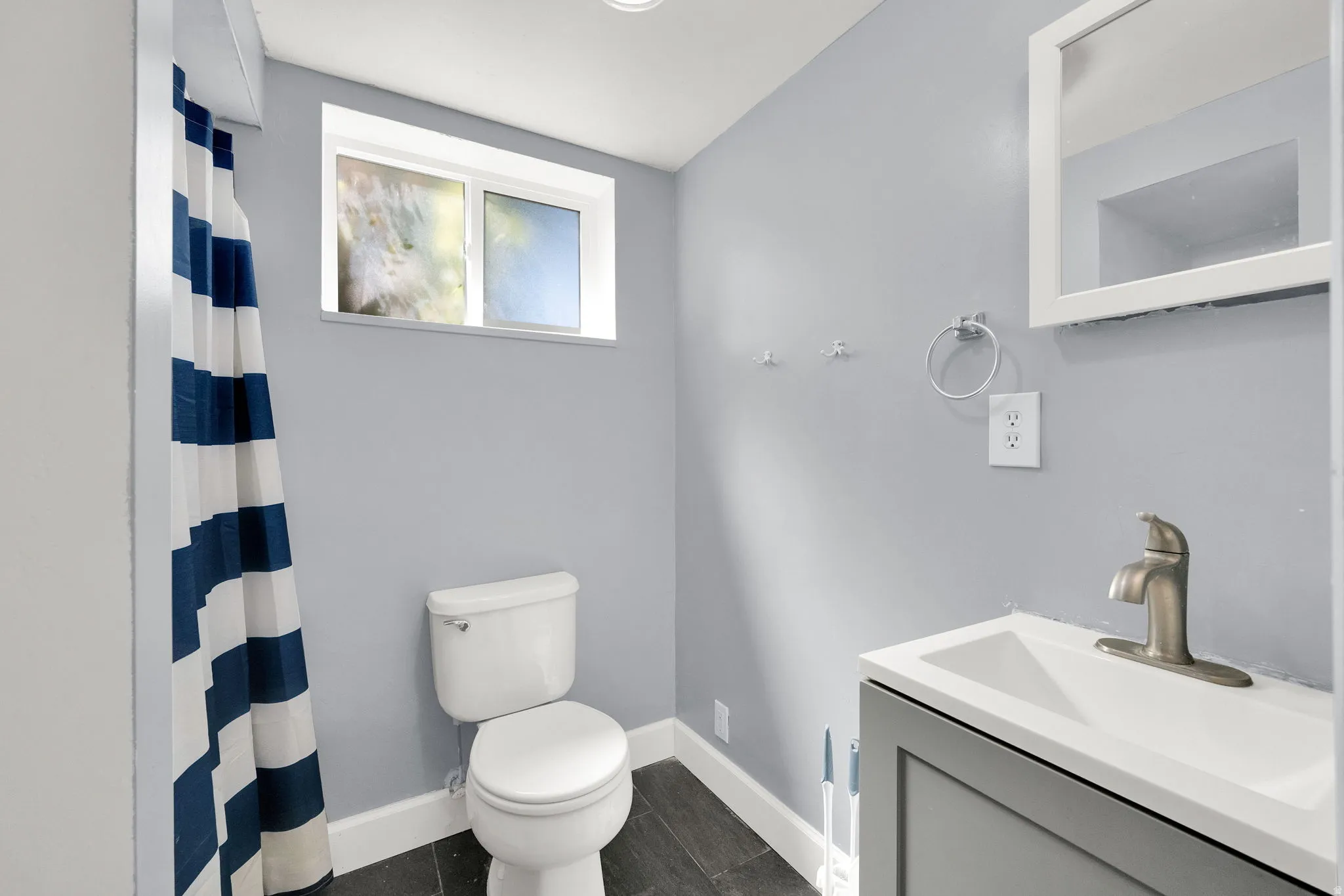Recessed lighting, wood-finish flooring, white toilet, vanity with integrated sink, and wall-mounted mirror