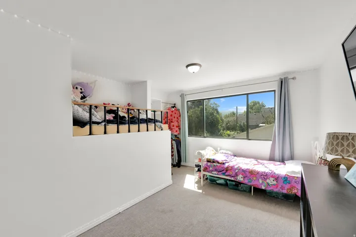 Loft space with a partial wall and a black metal railing