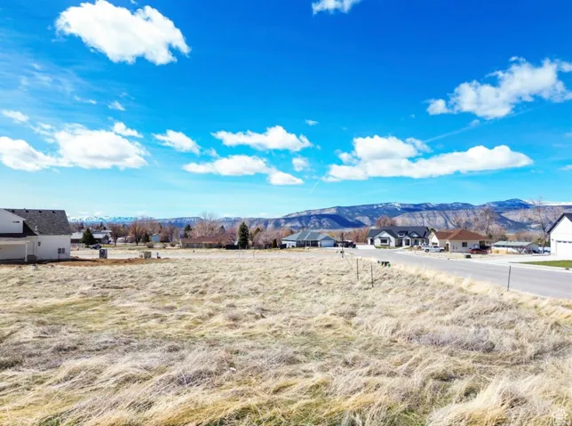 Expansive cleared lot featuring mountain scenery and an established neighborhood street