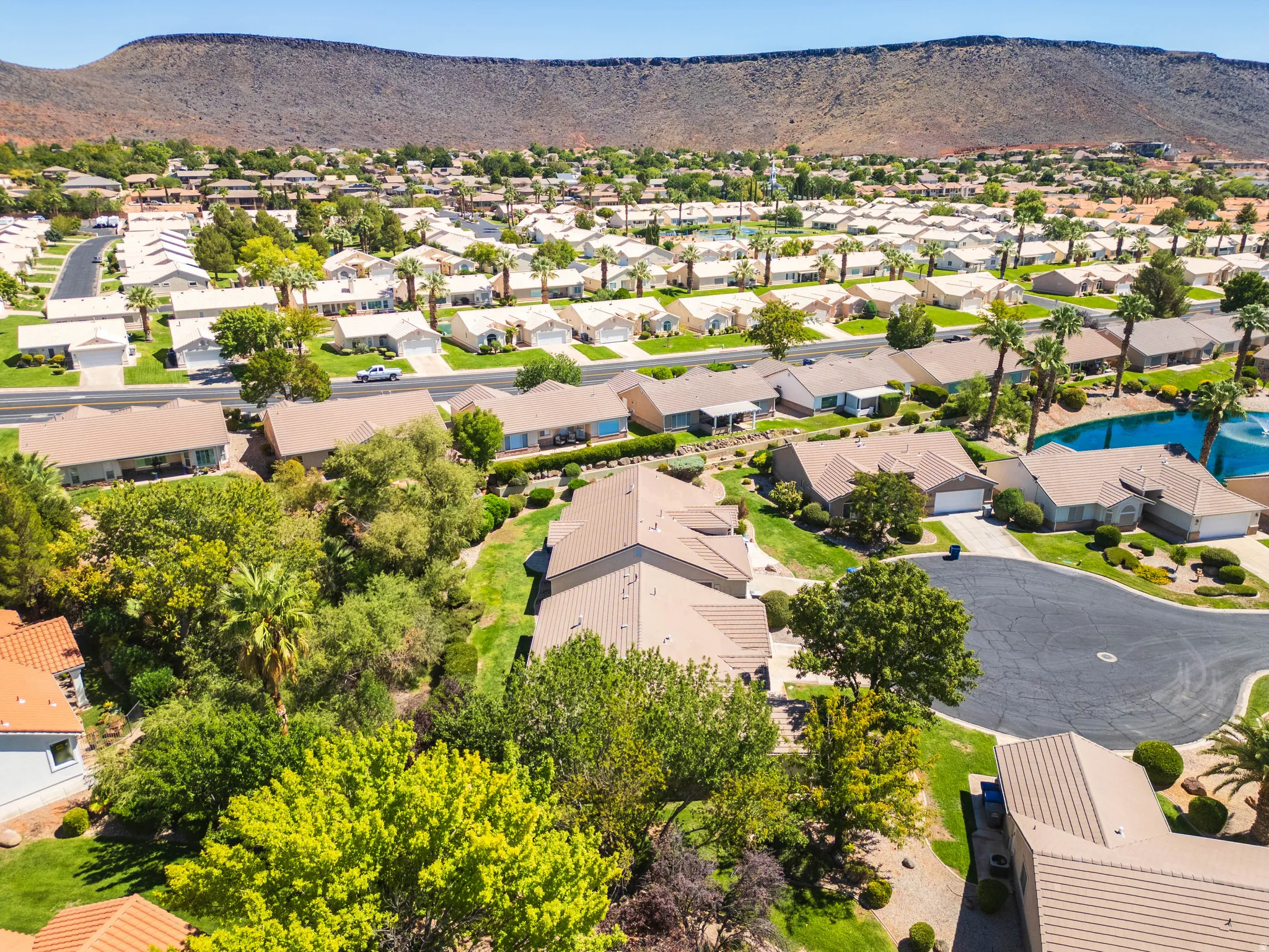 Residential neighborhood with single-story homes, mature landscaping, and mountain backdrop