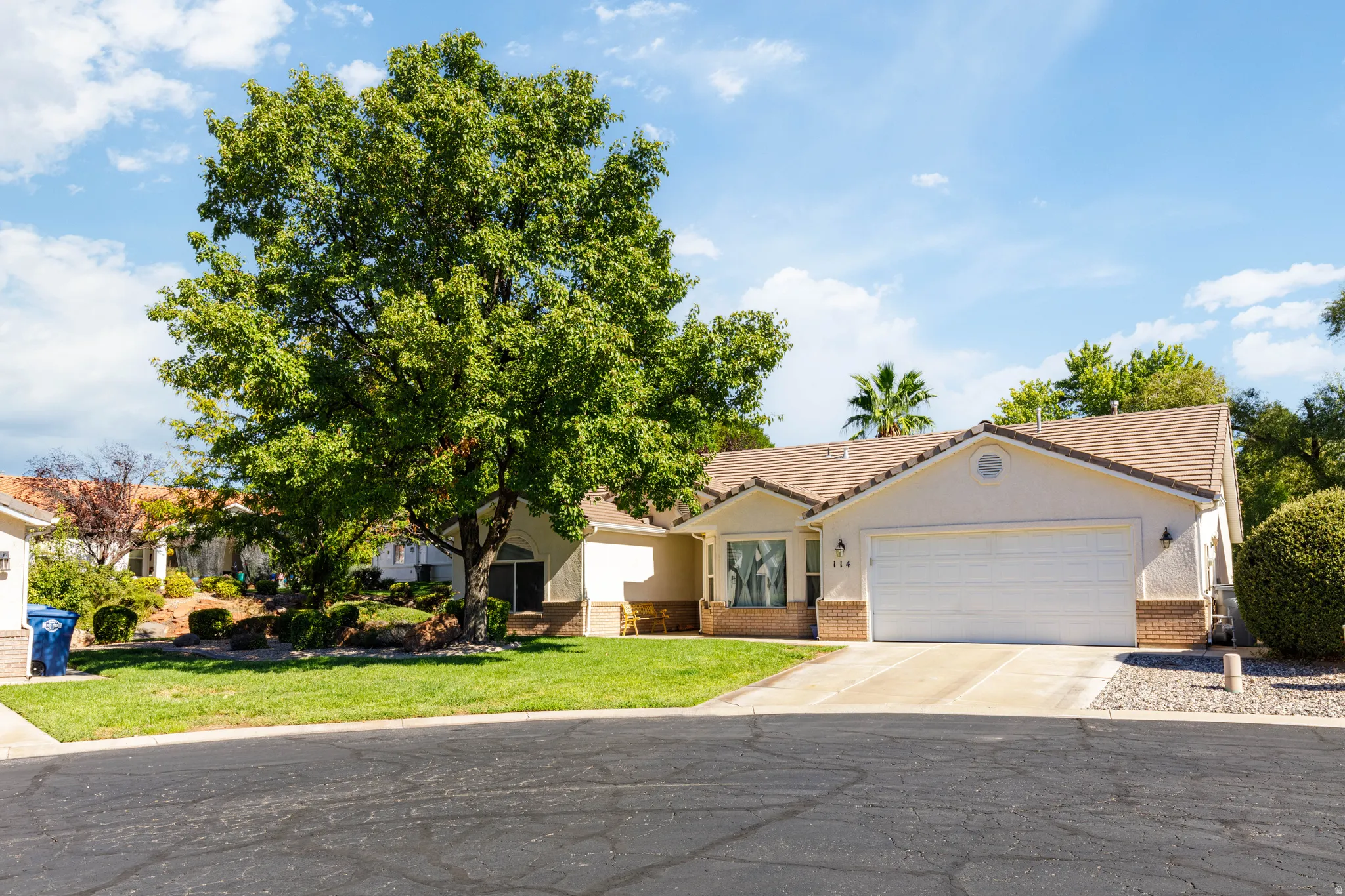 Single-story residence featuring a tile roof, an attached garage, and a concrete driveway