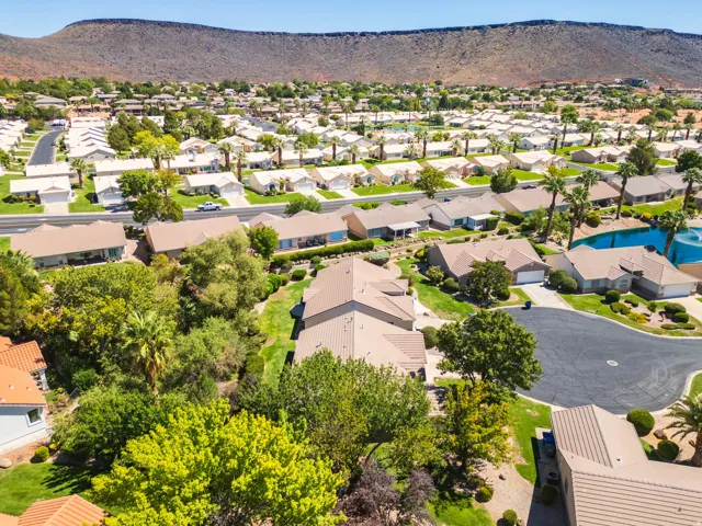 Residential neighborhood with single-story homes, mature landscaping, and mountain backdrop