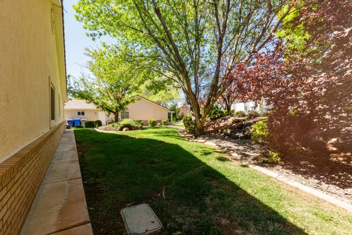 Expansive lawn area with mature trees and a structured rock garden