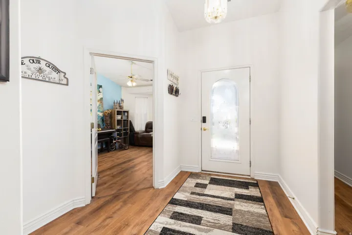 White entry door with an arched frosted glass insert and a smart lock