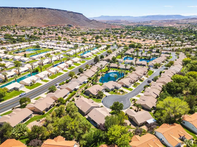Expansive residential community featuring multiple water features, mature palm trees, and mountain backdrops