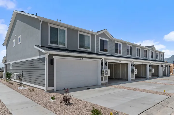 Contemporary multi-story exterior with a two-tone facade, attached garage, and multiple windows
