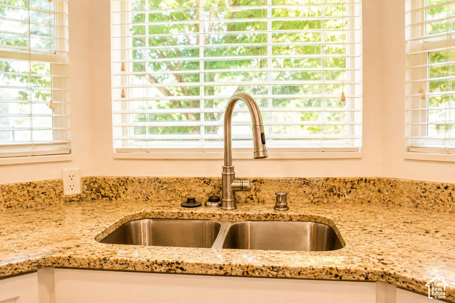 Kitchen featuring a stainless steel double basin sink, gooseneck pull-down faucet, and granite countertops