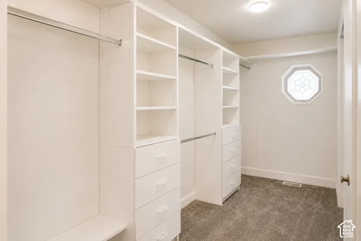 Custom closet organization system with integrated shelving, multiple hanging rods, and built-in drawers
