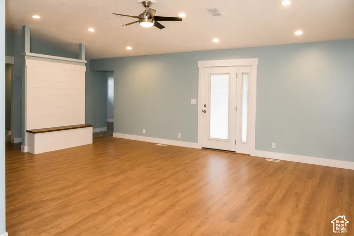 Open-concept living area featuring wood-finish flooring, recessed lighting, and a ceiling fan