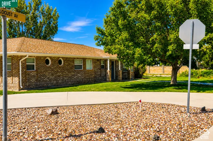 Brick exterior with a shingled roof, featuring multiple windows and two round accent windows