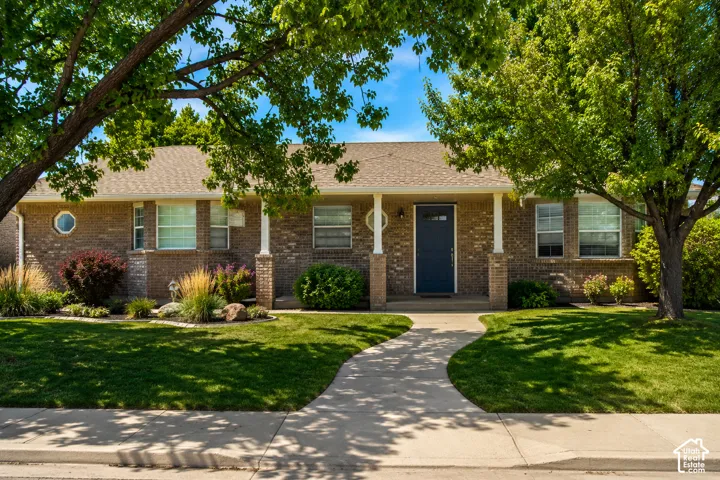Brick exterior with a shingled roof and covered front porch