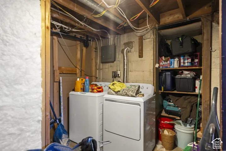 Laundry area with washer and dryer, exposed ceiling joists, wall insulation, and built-in shelving