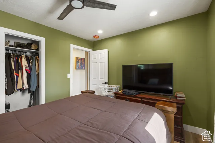 Ceiling fan with dark-toned blades, recessed lighting, and a built-in closet with shelving