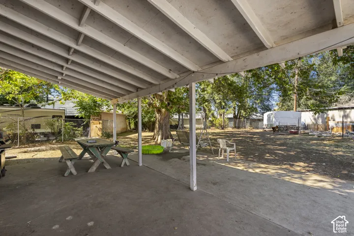 Covered patio with a concrete surface and expansive backyard space
