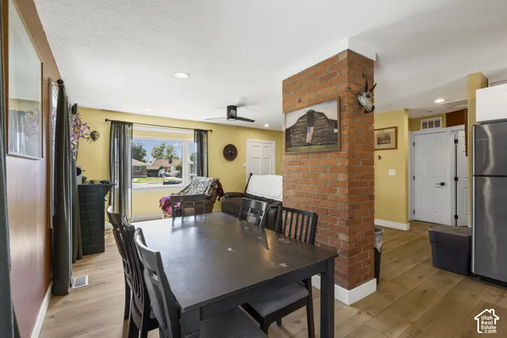 Exposed brick column, recessed ceiling lighting, wood-finish flooring, white trim, and a ceiling fan