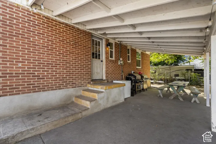 Covered patio area with brick exterior and concrete flooring