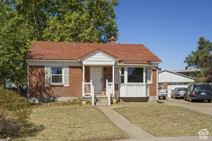 Brick exterior with a tiled roof, covered front porch, and a bay window