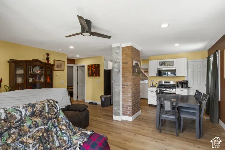 Open-concept living space with wood-finish flooring, recessed lighting, and a ceiling fan