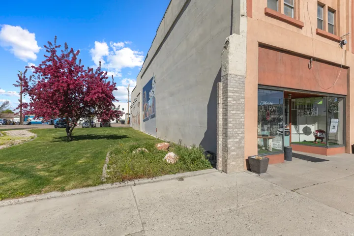 Commercial storefront with large display windows, brick pillar accents, and a wide sidewalk