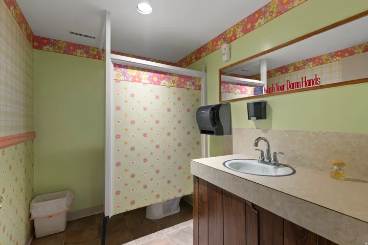 Bathroom featuring a built-in vanity with an integrated sink, a wall-mounted mirror, and recessed lighting