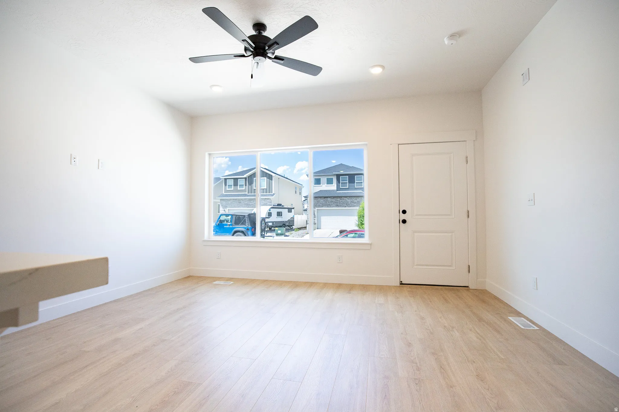Family room with 9' ceiling and ceiling fan.