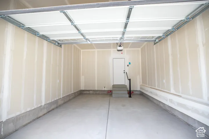 Single car garage with additional space for storage and taped finish.