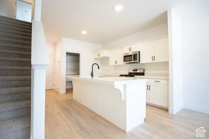 Terrific kitchen with painted white wood cabinets, walk-in pantry, quartz slab countertops, gas range, microwave and disposal.